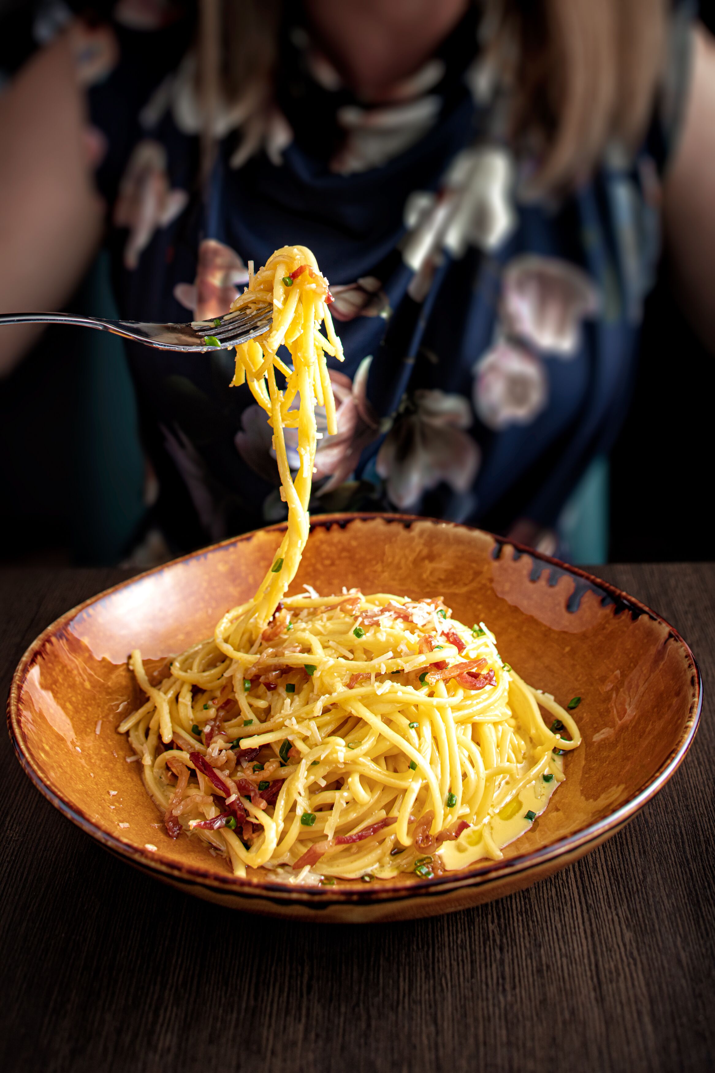 En skål med spaghetti, och en gaffel lyfter upp några nudlar.