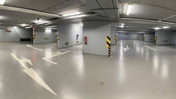 A multi-level parking garage with clear directional arrows and safety bollards.