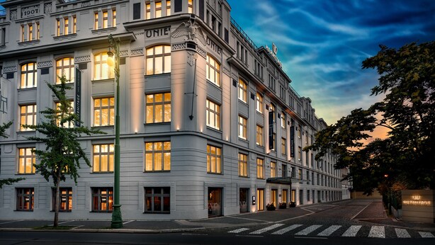 A historic building with multiple stories, large windows, and a prominent 'UNIE' sign. - Hermitage Hotel Prague (Prague)