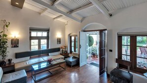 Amplia sala de estar con techo alto, ventanas grandes y vistas al exterior.