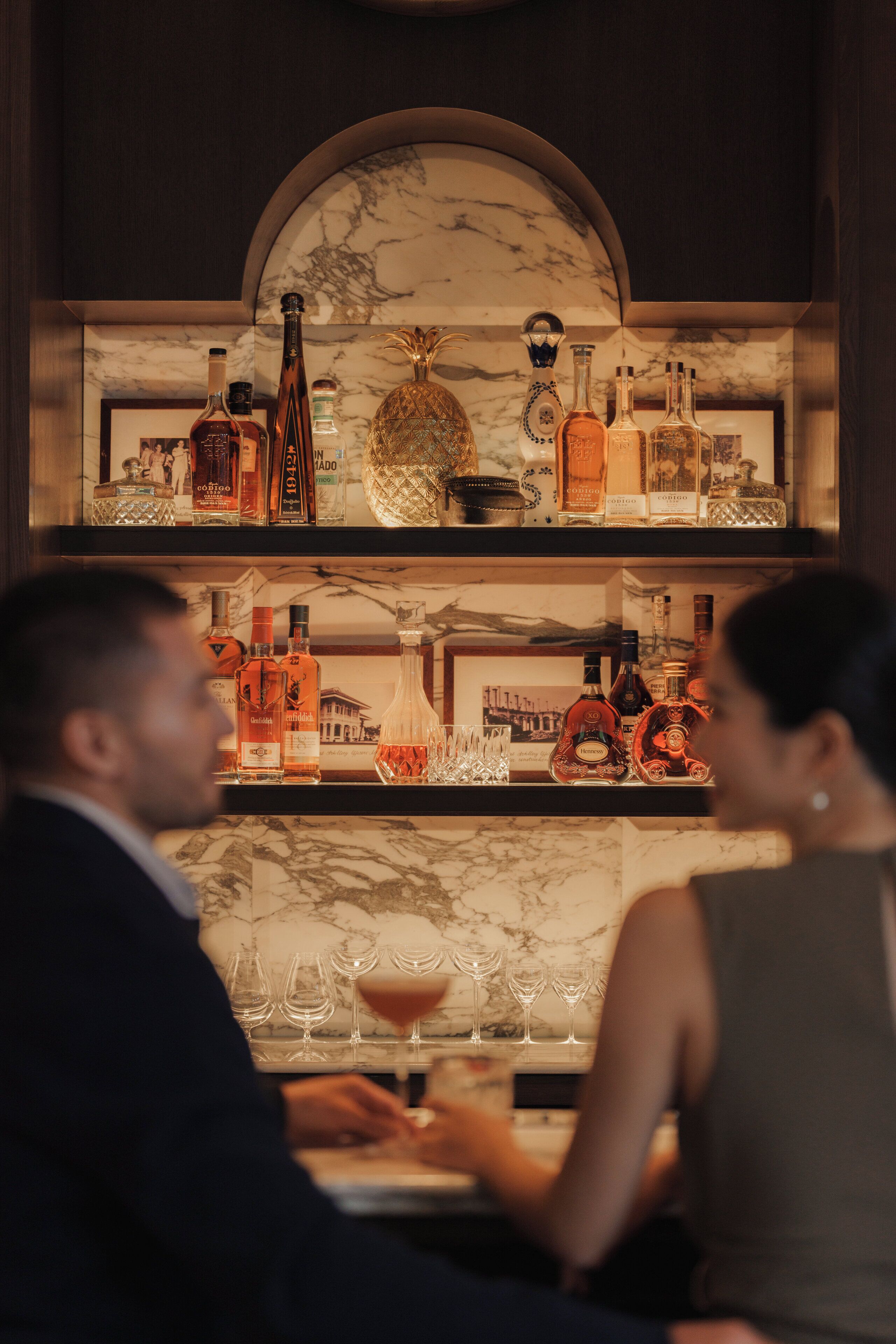 A bar area with shelves of liquor bottles and glasses.