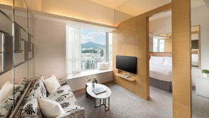 A modern hotel room with a sofa, a small table, a TV, and a bed. - Dorsett Mongkok, Hong Kong (Kowloon)