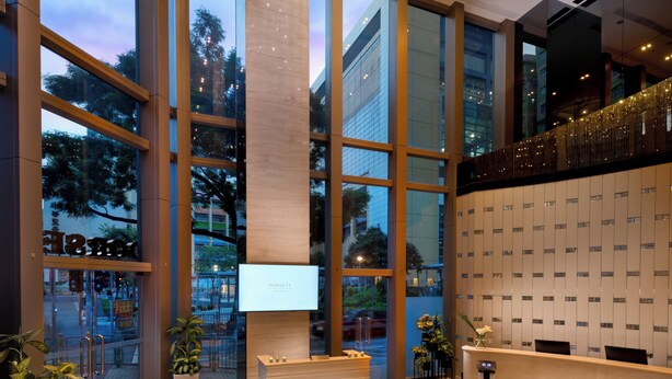 A modern lobby with large windows, a reception desk, and a chandelier. - Dorsett Mongkok, Hong Kong (Kowloon)