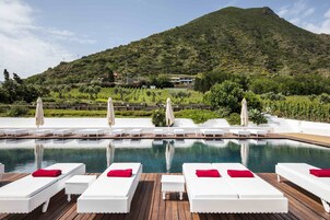 Una piscina al aire libre, sillones reclinables de piscina