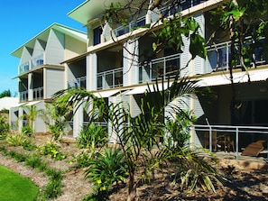 A multi-story building with balconies, surrounded by tropical plants and a well-maintained garden. - Oaks Broome Hotel (Broome)