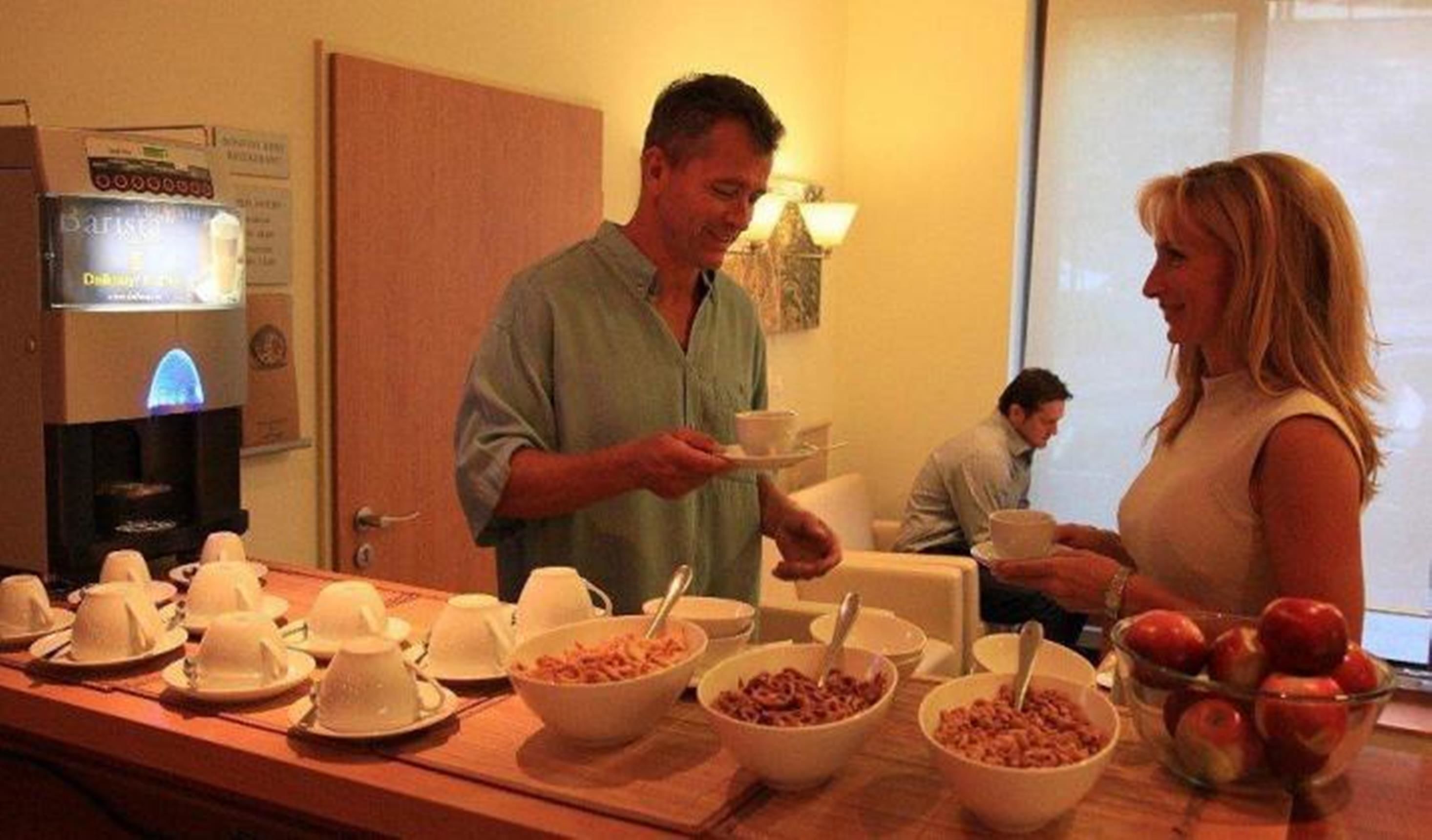 A buffet setup with multiple bowls of food and a coffee machine.