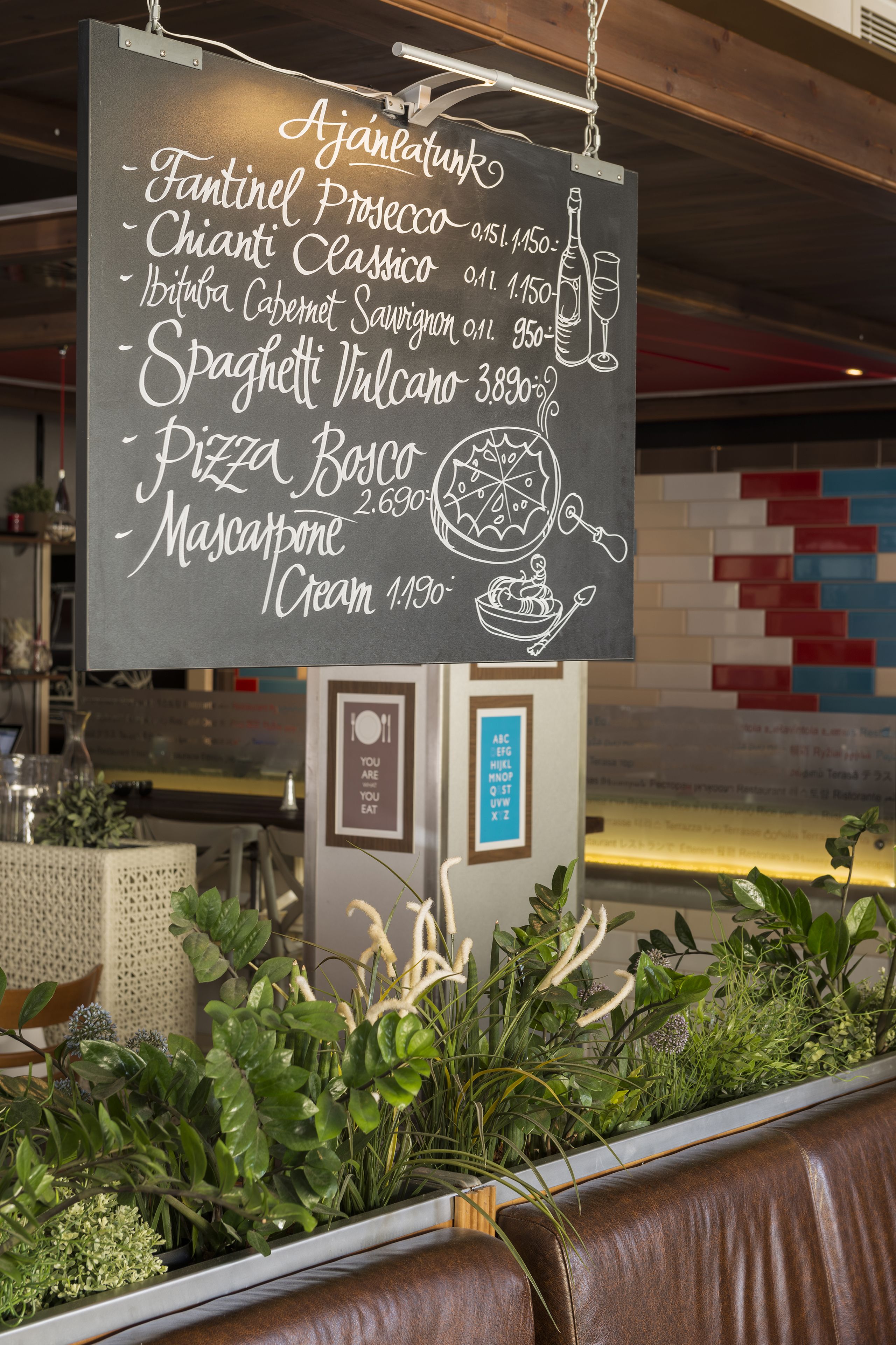 Un cartel con el menú que muestra diferentes alimentos y precios en un restaurante.