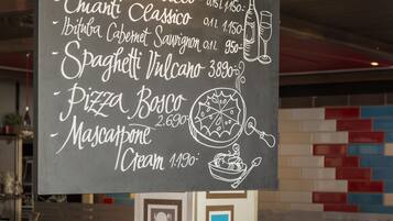Un cartel con el menú que muestra diferentes alimentos y precios en un restaurante.