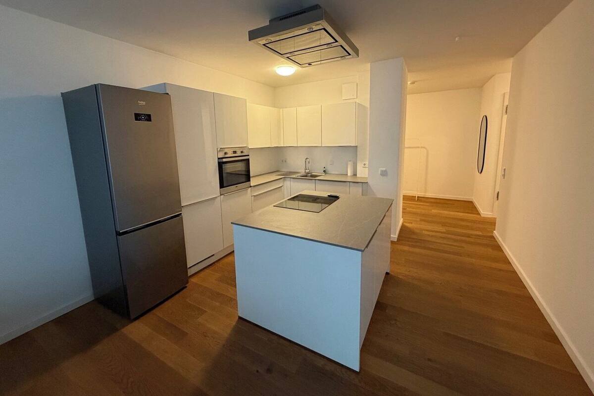 A compact kitchen with a built-in refrigerator, a central island, and a small oven.