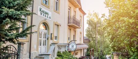 A building with a sign reading "KALMA VILLA" and a restaurant sign "CHILLERME Café & Grill" in front.