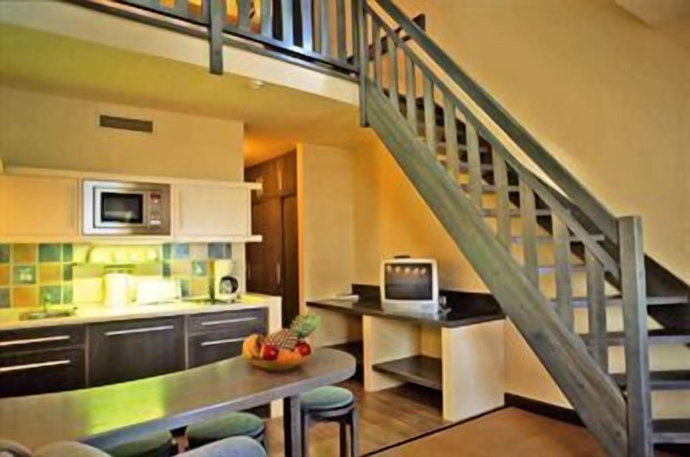 A modern kitchen with a microwave, stove, and a small television on a counter.