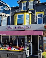 The Arthington, um edifício com uma placa de destaque, janelas amplas e um toldo amarelo.