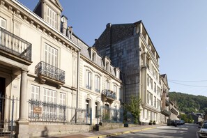Une rangée de bâtiments historiques aux balcons richement décorés, sous un ciel dégagé.