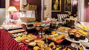Un buffet con diversi piatti e uno specchio che riflette un quadro.