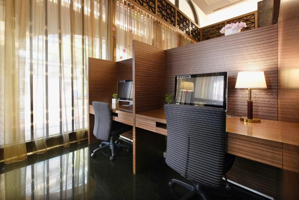 Un espacio de oficina moderno con un escritorio de madera, una computadora y una silla.