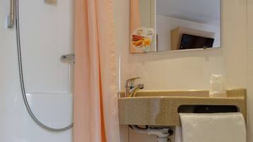 A bathroom with a shower, a sink with a towel, and a mirror.