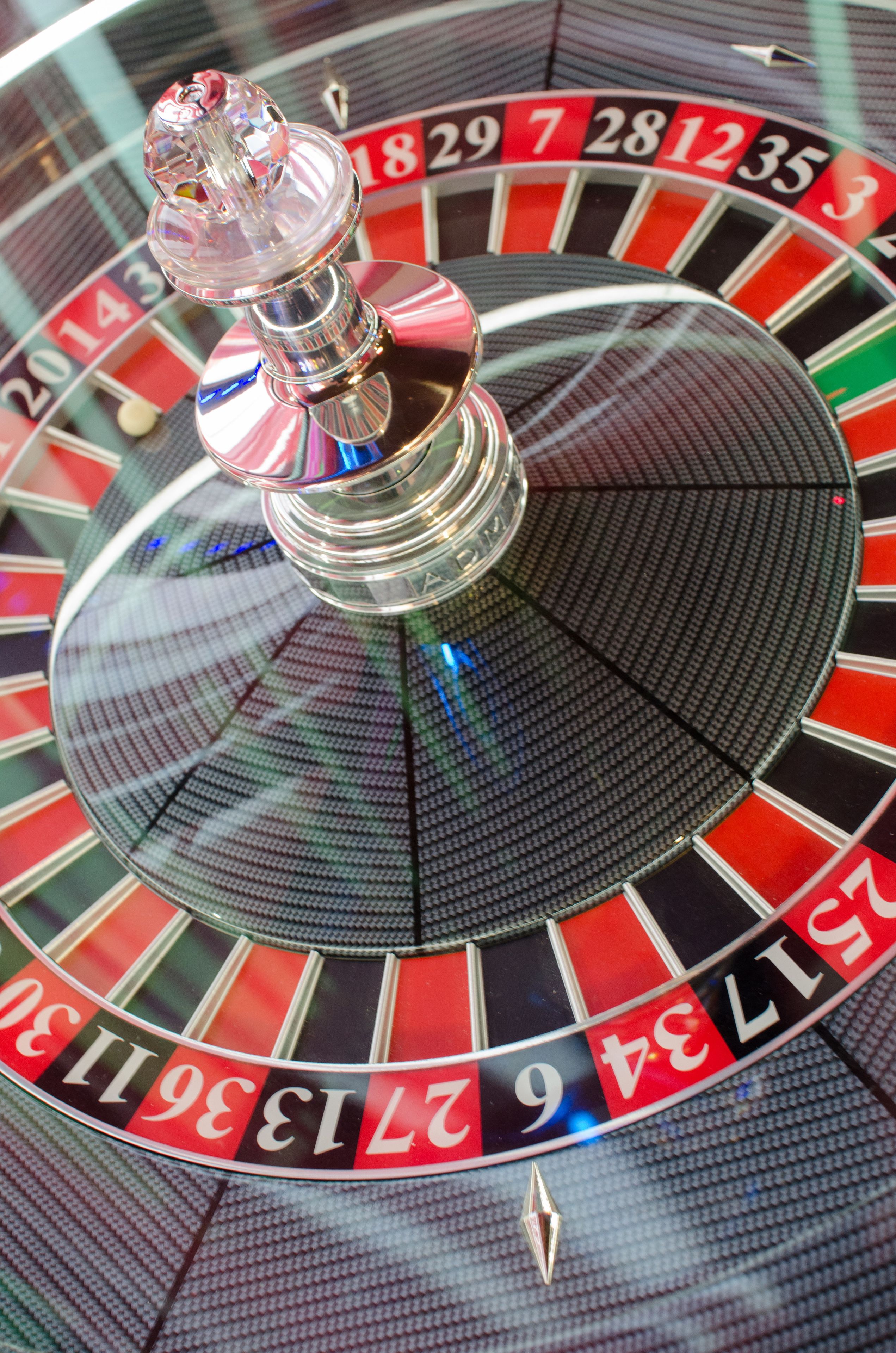 A close-up of a roulette wheel with numbered slots and a spinning ball.