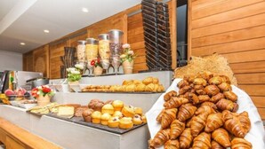 Un bufé con diferentes productos de repostería, incluyendo croissants y muffins.