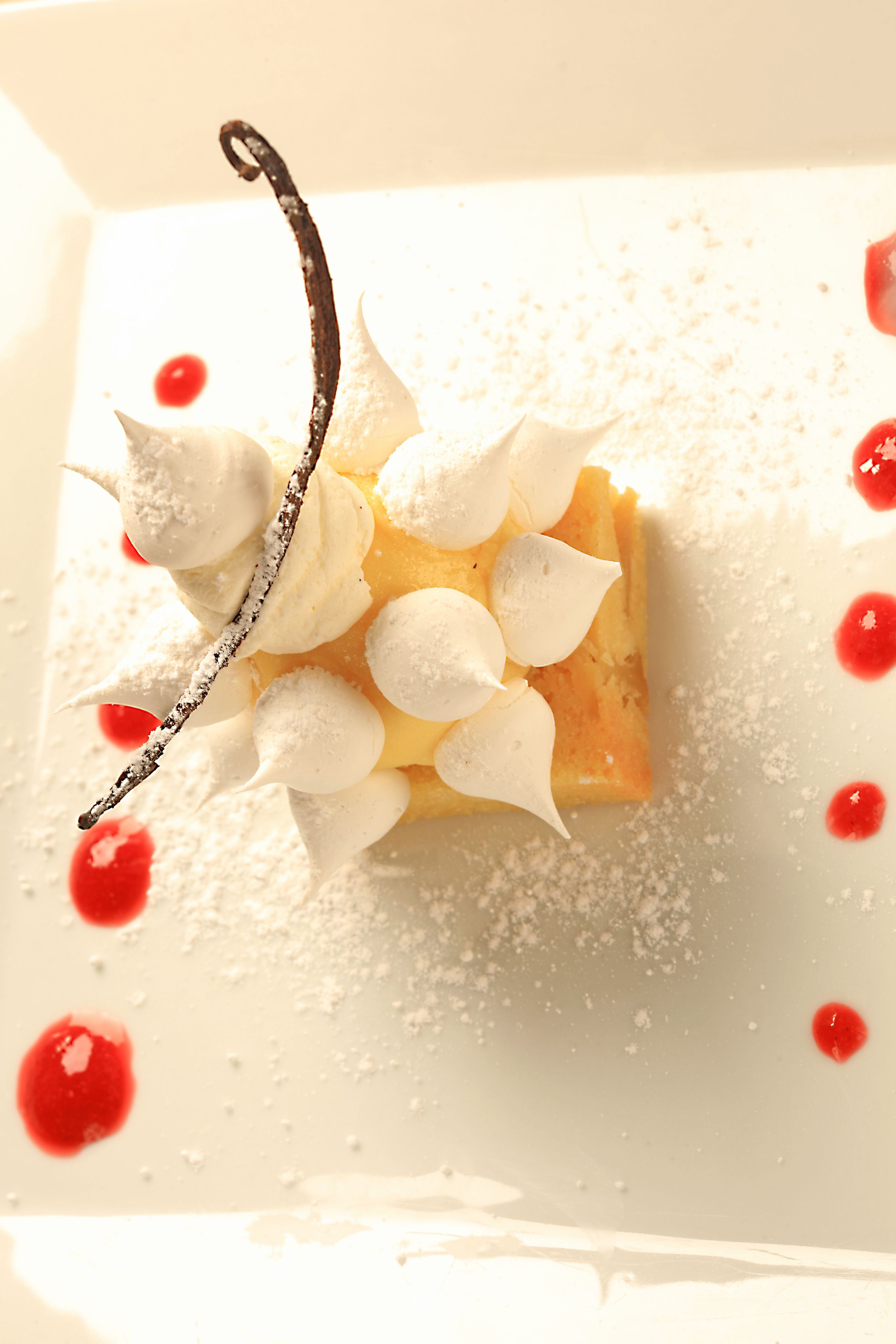 A dessert with whipped cream and a chocolate piece on a plate.