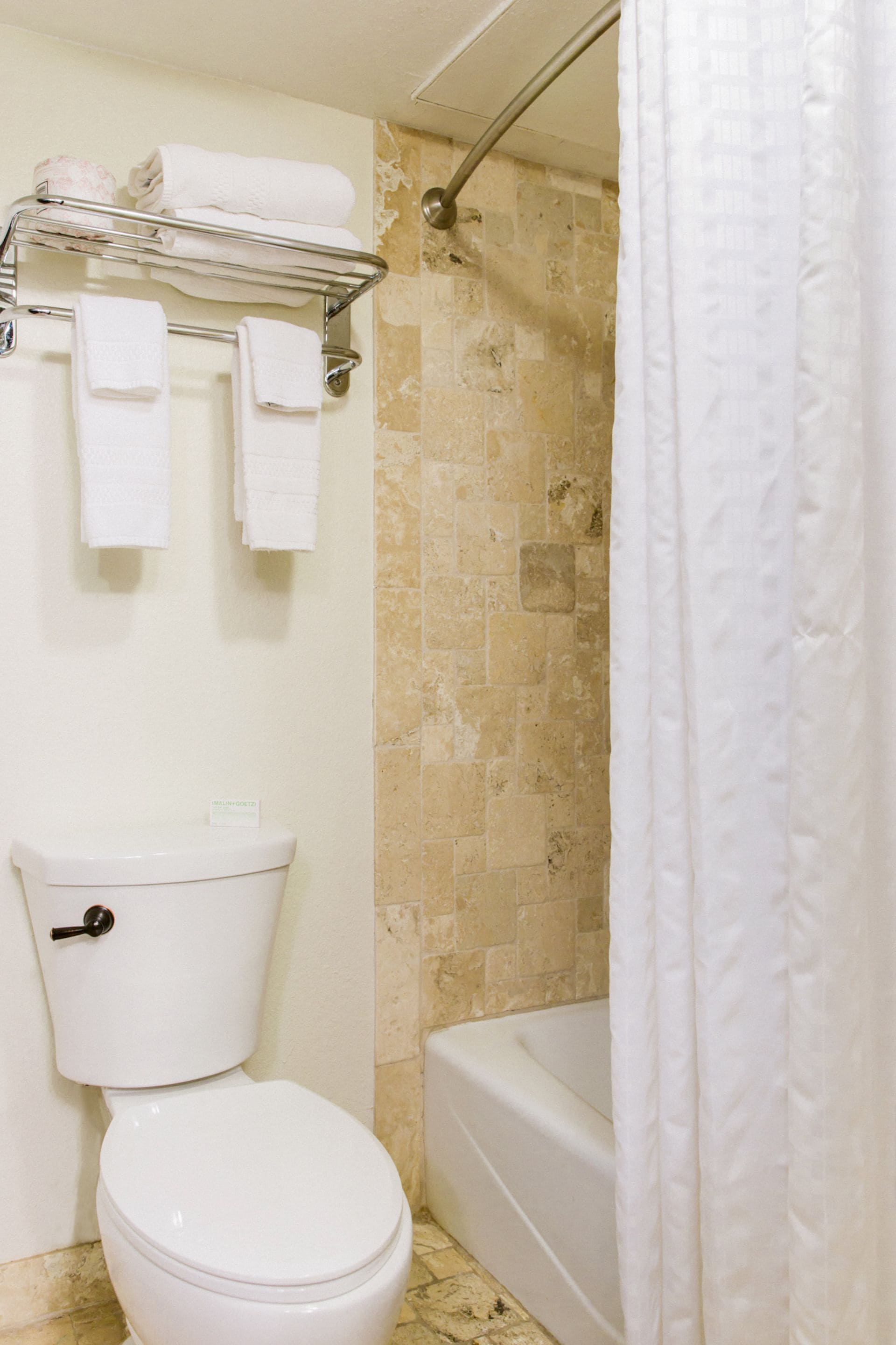 Un baño con inodoro, bañera y cortina de ducha.