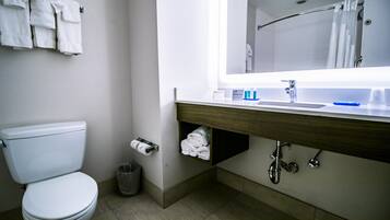 A modern bathroom with a toilet, a sink with a mirror, and a towel rack.