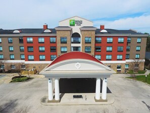 A hotel with a central entrance, multiple floors, and a distinctive red and white color scheme.