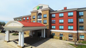A Holiday Inn Express building with a red roofed pavilion, multiple floors, and a brick facade.