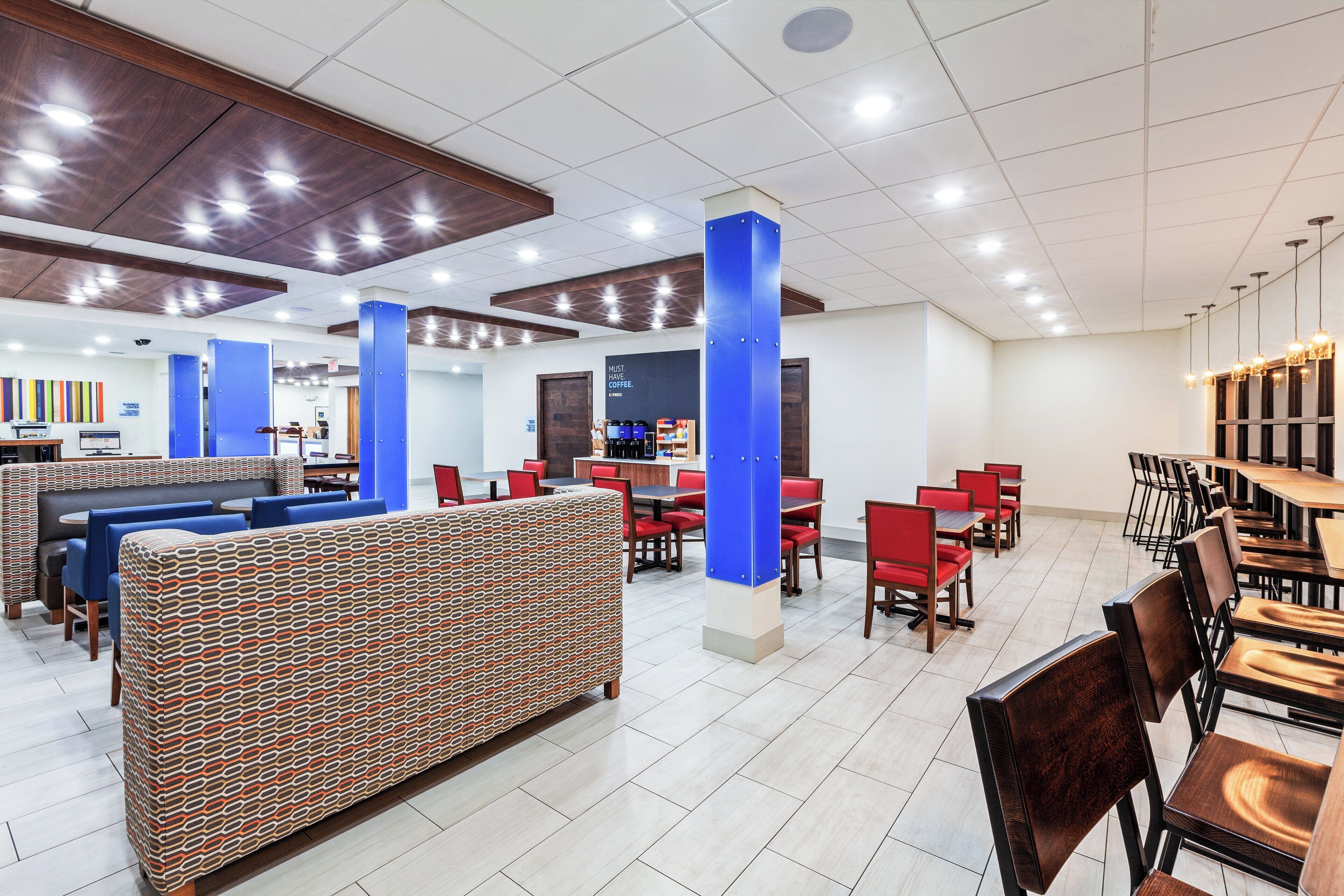 Un amplio espacio interior con diversas opciones de asientos, incluyendo cabinas y mesas, además de una barra probablemente para pedir comida o bebidas.