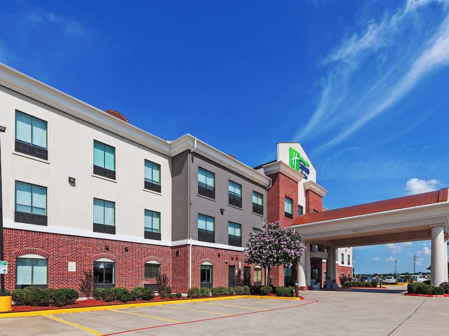 A hotel with a red brick facade, multiple windows, and a clear blue sky.