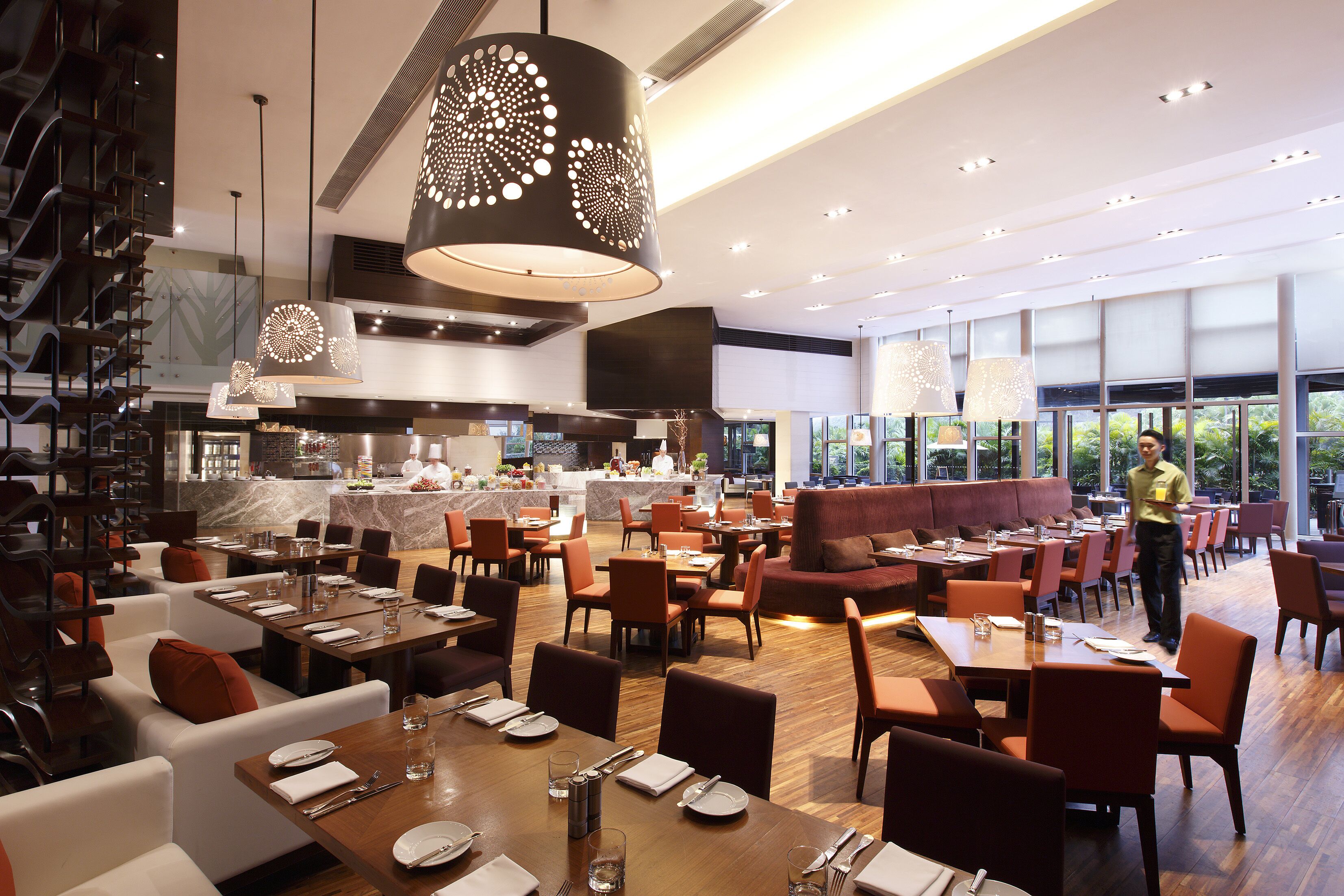 Un restaurante espacioso con varias zonas de comedor, incluyendo un bar y un área con vistas al exterior.