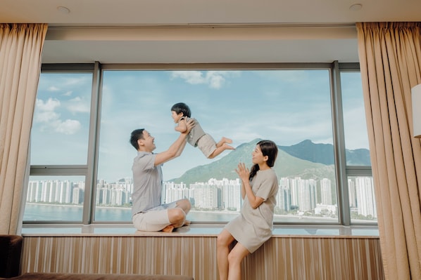 A room with a large window overlooking a cityscape and mountains. - Hyatt Regency Hong Kong, Sha Tin (Sha Tin)