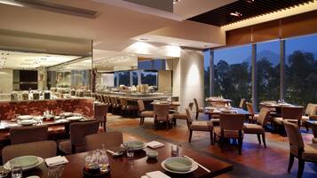 Un comedor moderno con varias mesas, sillas y vistas al exterior.