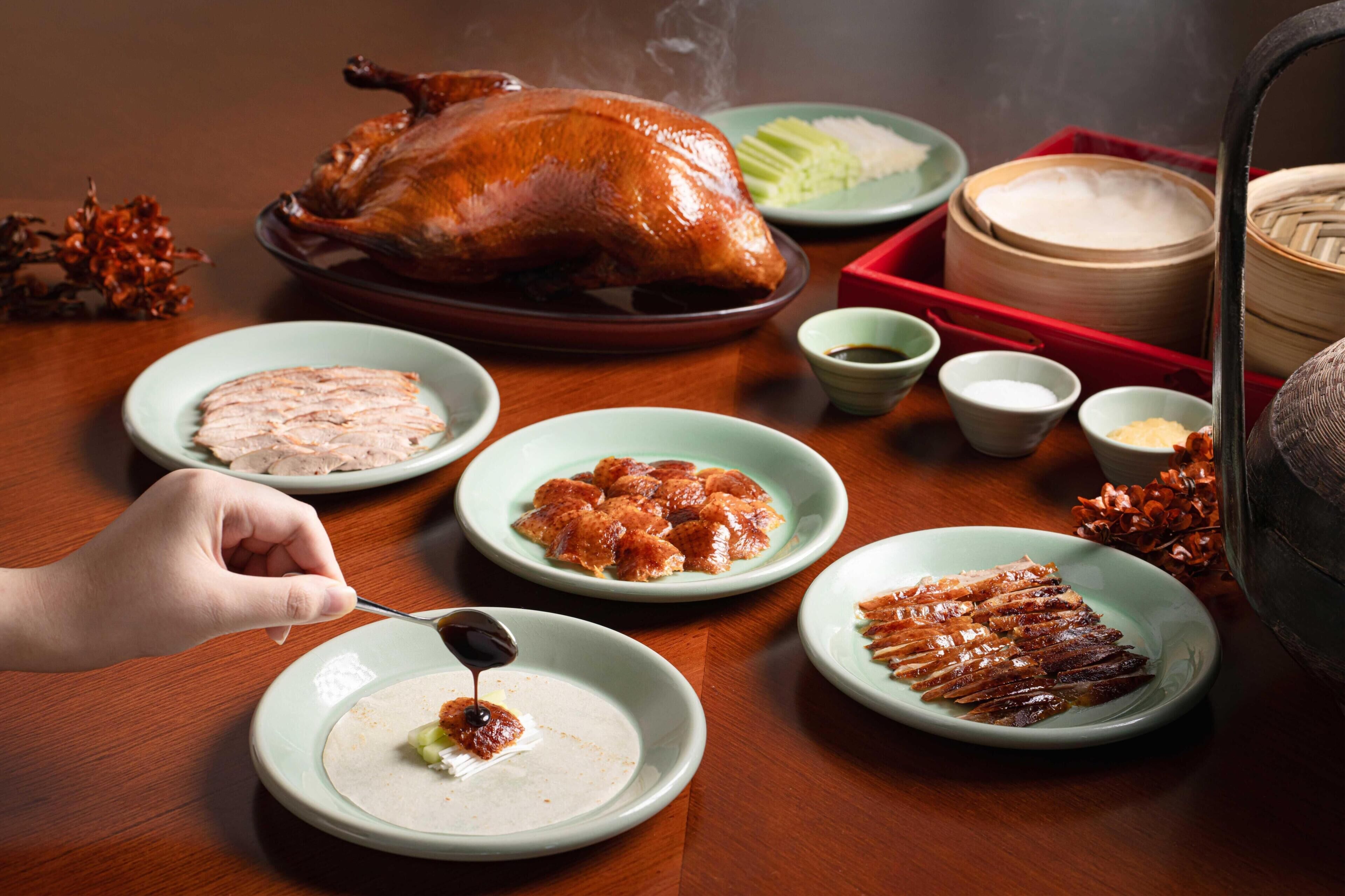 A table with a roasted chicken, various dishes, and a steaming pot.