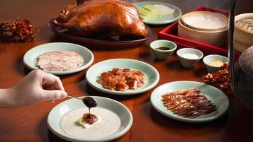 A table with a roasted chicken, various dishes, and a steaming pot.