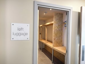 Ein Raum mit einem Schild, auf dem 'Loft Gepäck' steht, und einem Bettgestell mit Etagenbetten.