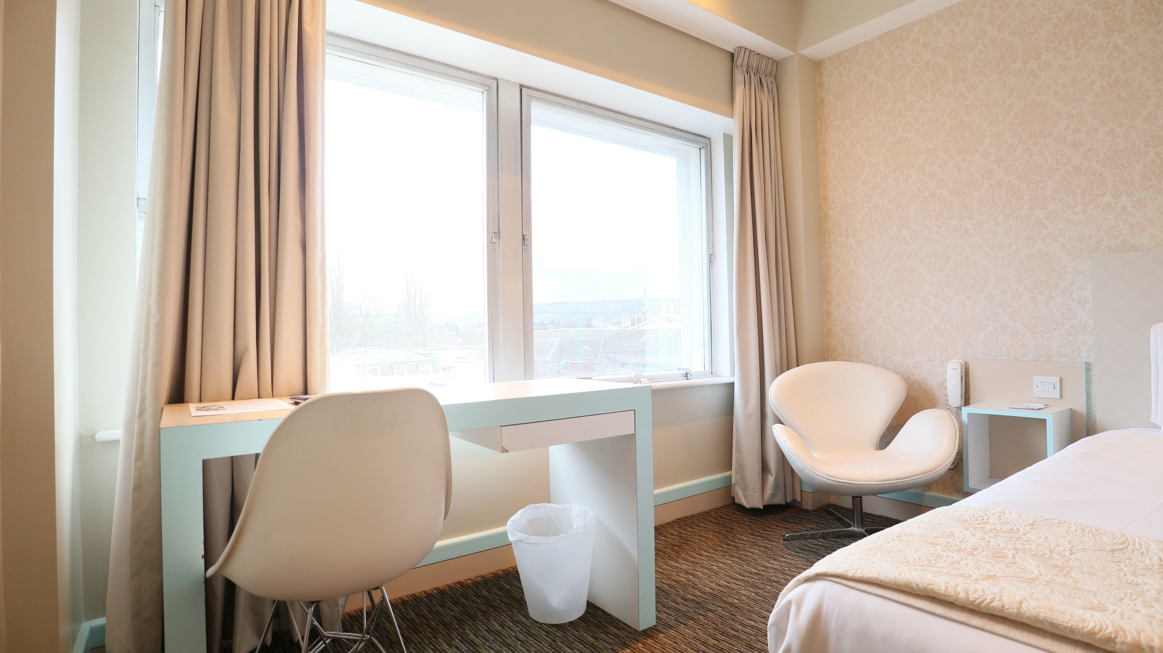 Una habitación de hotel con escritorio, silla y cama.