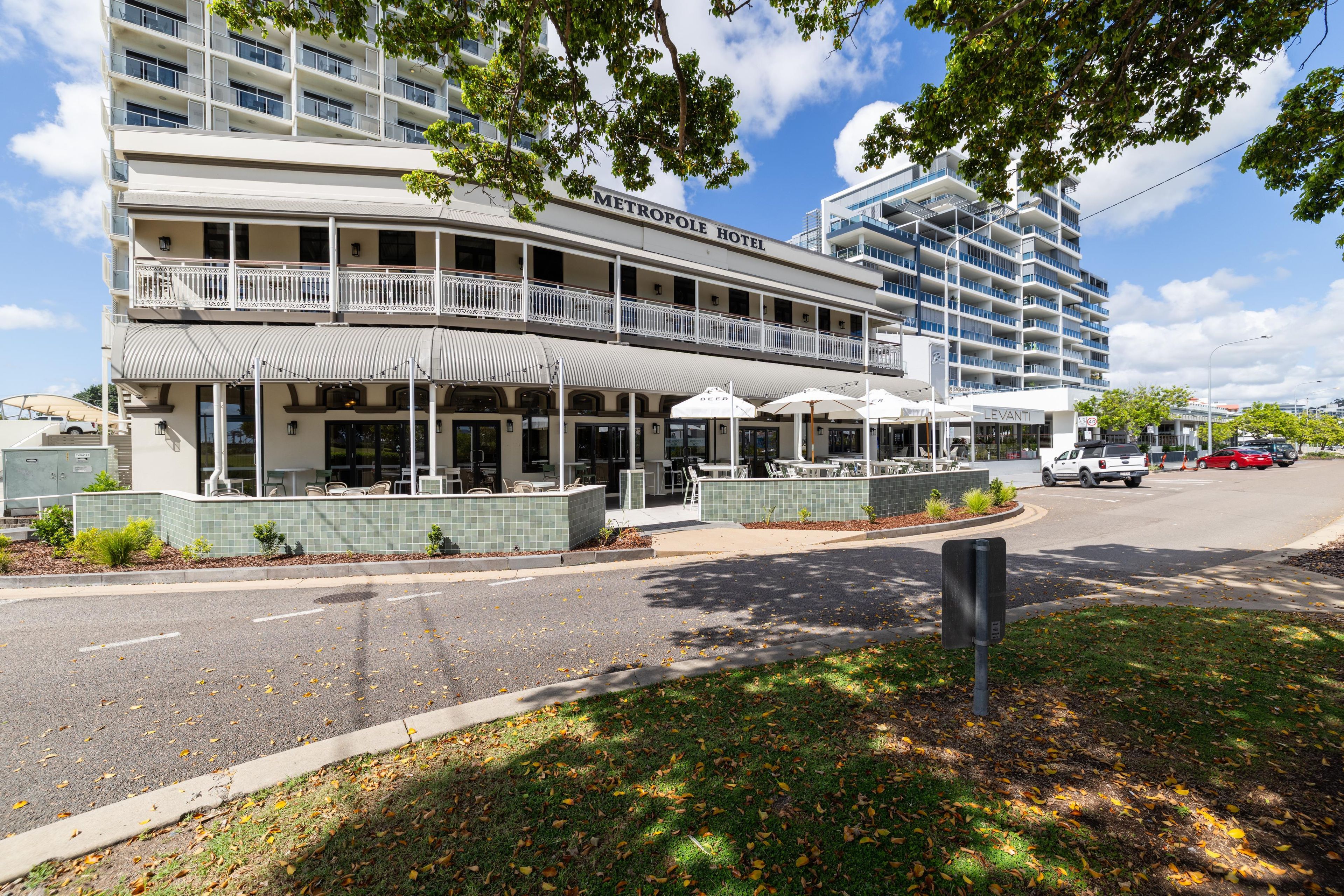 A hotel with a two-story structure, outdoor seating area, and a covered patio.