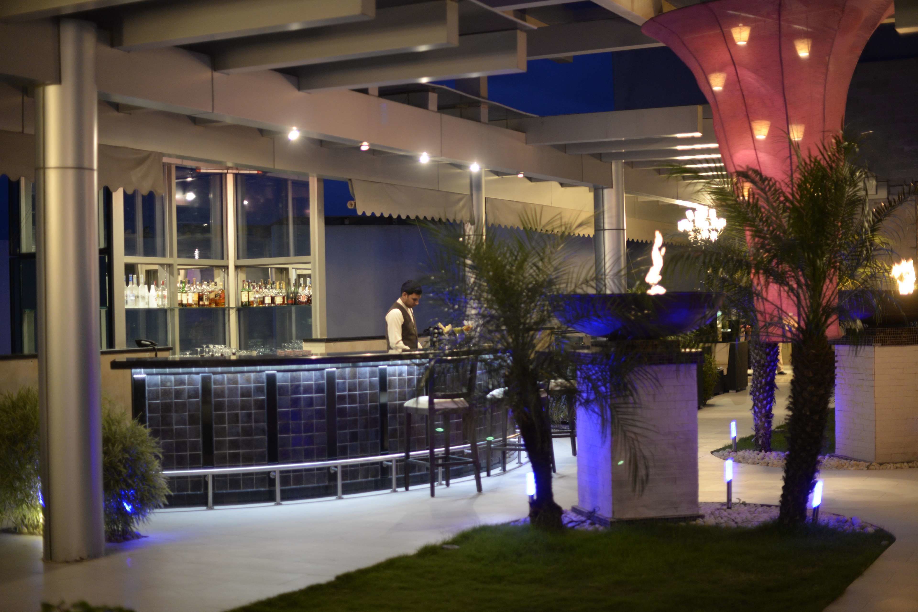 An outdoor bar area with a counter, seating, and a decorative structure.
