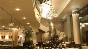 A spacious lobby with a grand staircase, elegant chandeliers, and plush seating areas. - The Zuri Whitefield, Bangalore (Bengaluru)