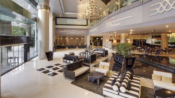 A spacious lobby with modern furniture, a large chandelier, and a glass railing overlooking the area. - The Zuri Whitefield, Bangalore (Bengaluru)