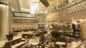 A spacious lobby with multiple seating areas, a reception desk, and a staircase leading to upper floors. - The Zuri Whitefield, Bangalore (Bengaluru)