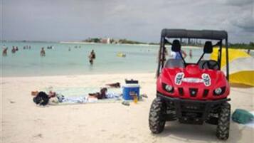 Una playa cerca, arena blanca, sillas reclinables de playa