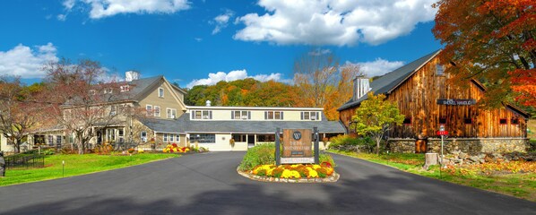 A quaint inn with a welcoming entrance, a shovelful handle pub sign, and a stone wall.