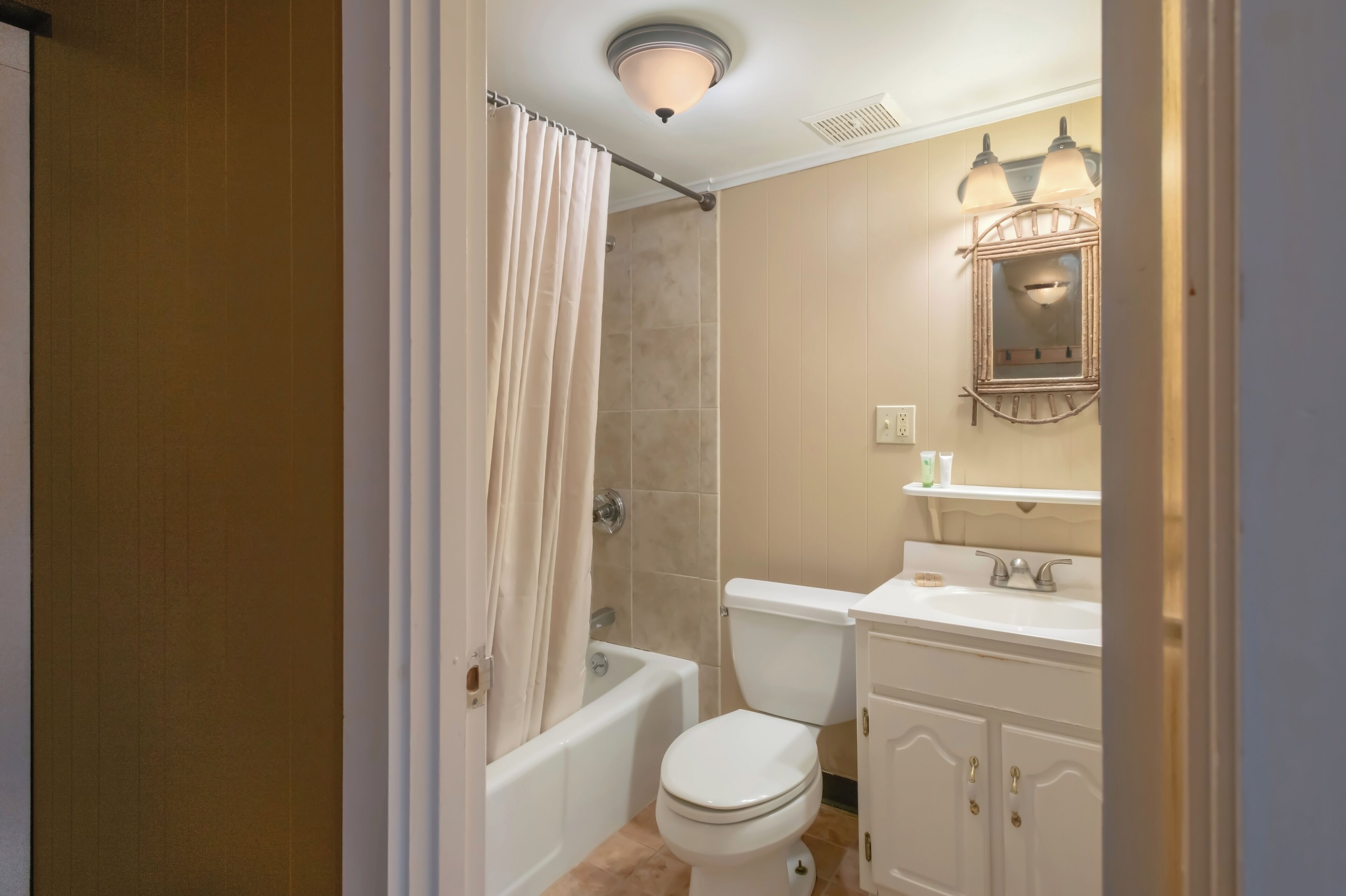 A bathroom with a bathtub, toilet, and sink.