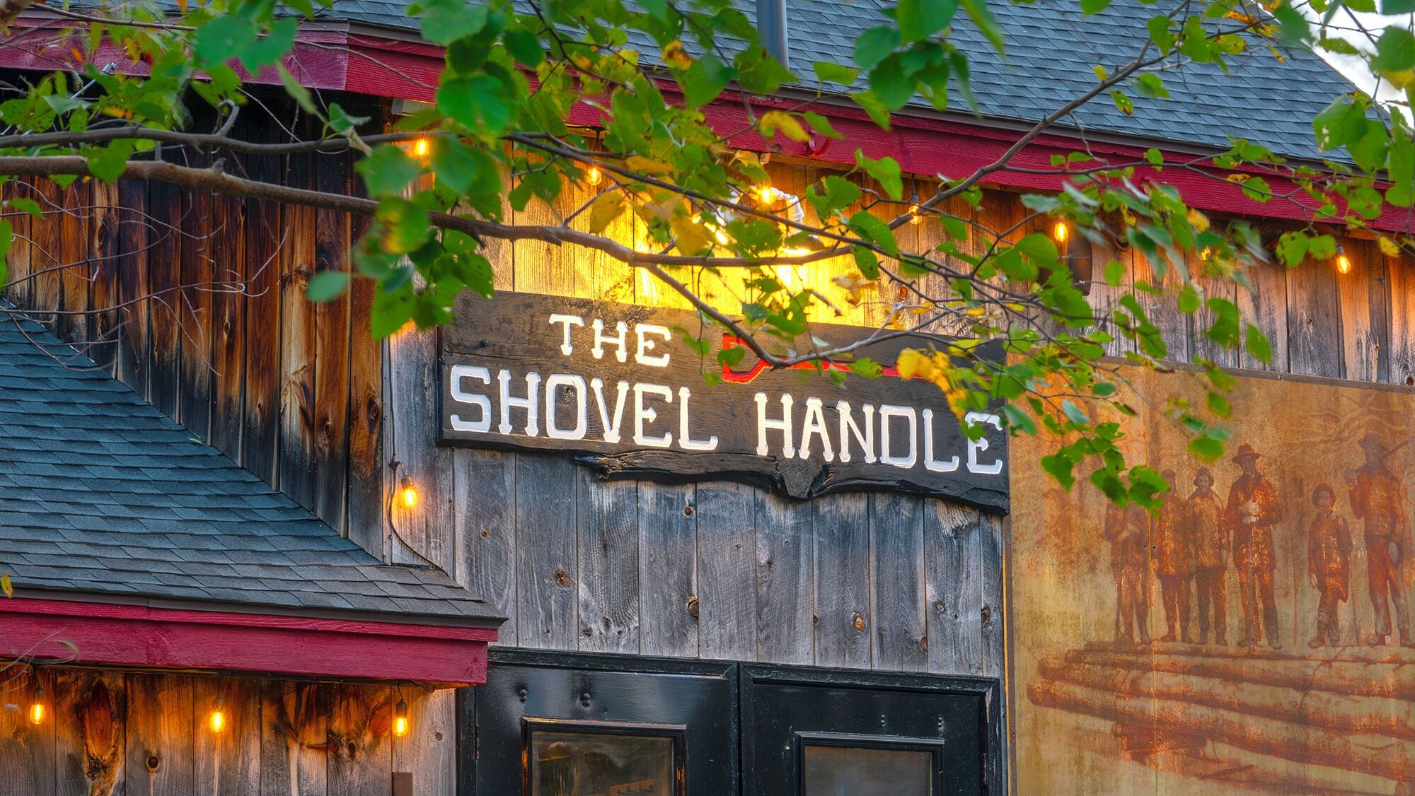 A wooden building with a sign that reads "The Shovel Handle."