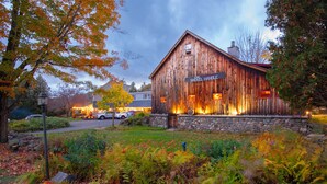 A rustic wooden building with a stone foundation, a sign reading "The Shovel Handle," and a stone wall with windows. - Whitneys Inn at Black Mountain (Jackson)
