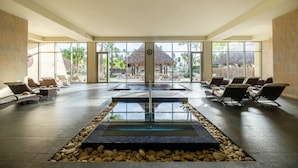 A spacious indoor area with a pool, lounge chairs, and a view of a tropical resort. - Barceló Bávaro Palace - All Inclusive (Punta Cana)