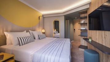 A modern bedroom with a large bed, bedside tables, a mirror, and built-in shelving.