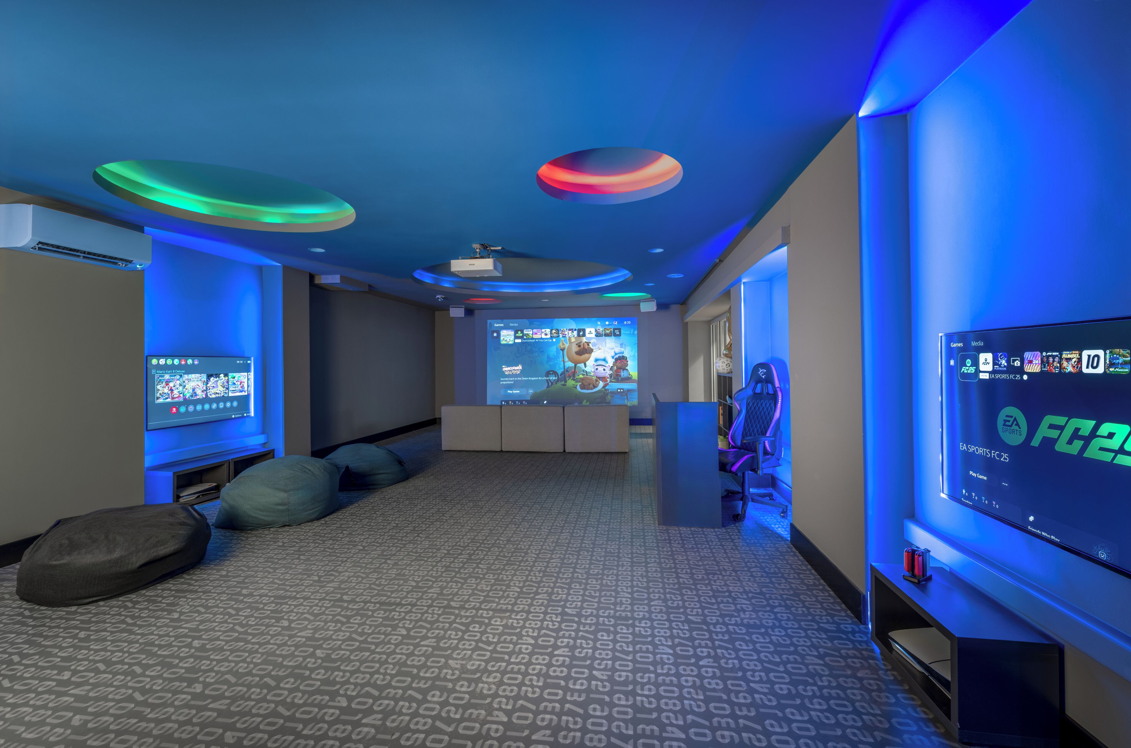 Una sala de cine en casa moderna con una pantalla grande, asientos cómodos y una consola de videojuegos.