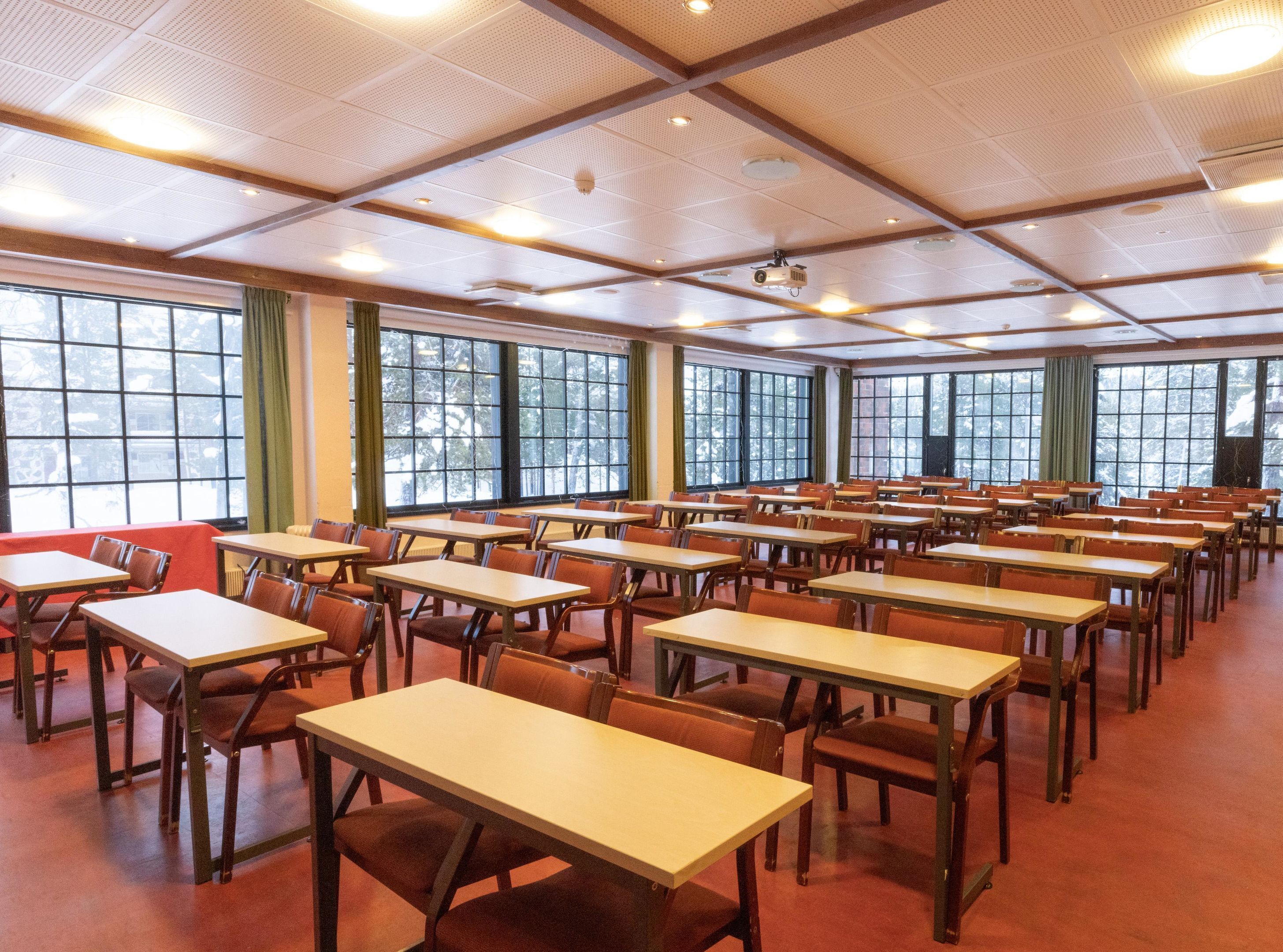 Uma sala de conferências com mesas e cadeiras dispostas para uma reunião.
